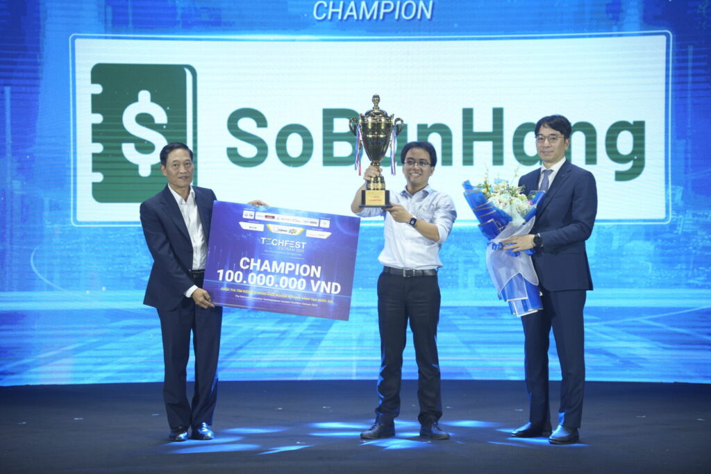 Thứ trưởng Khoa học và Công nghệ Trần Văn Tùng (trái) và Giám đốc Tập đoàn Tài chính Shinhan, ông Hyuk Choi trao bảng giải thưởng, cúp và hoa cho Quán quân cuộc thi